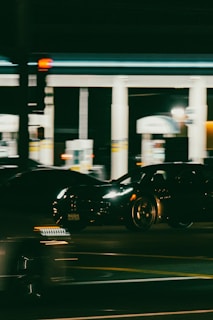 Sleek black truck with gold and aqua branding speeding along a futuristic highway at dusk.