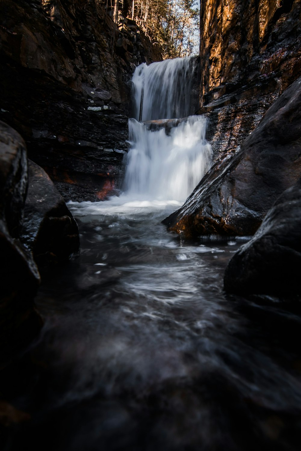 a small waterfall in the middle of a forest