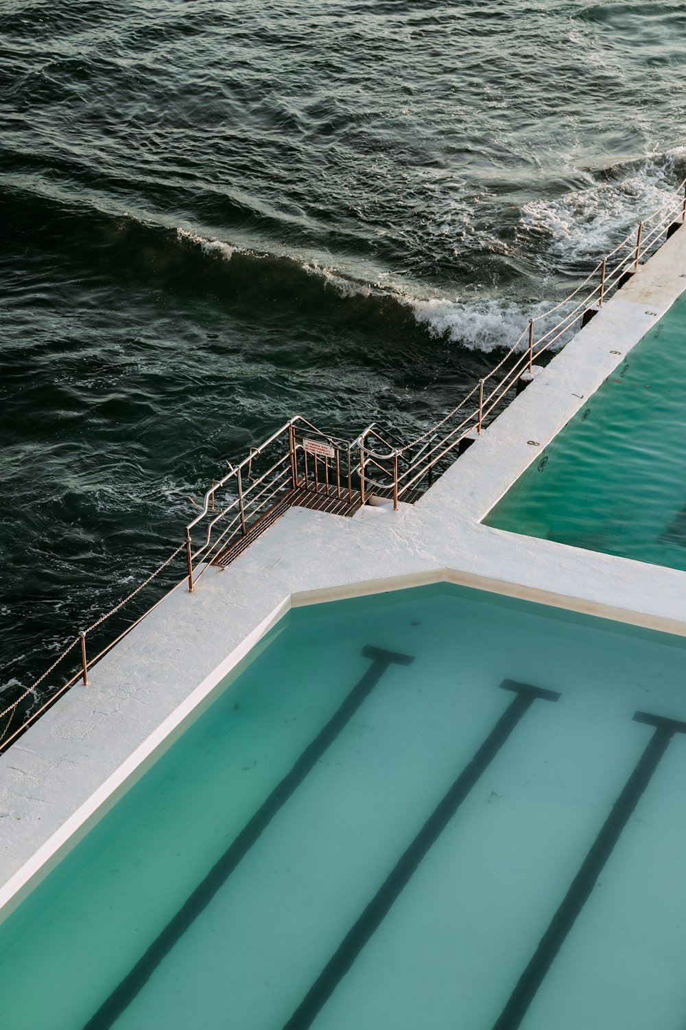 a large swimming pool next to a large body of water