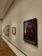 A softly lit gallery wall featuring warm orange and beige artwork.