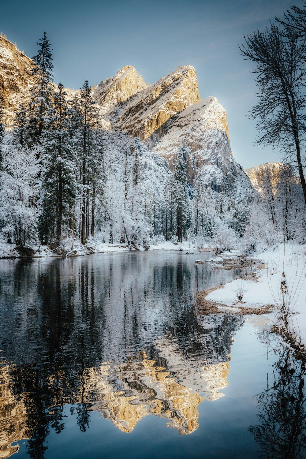 a lake surrounded by snow covered mountains and trees