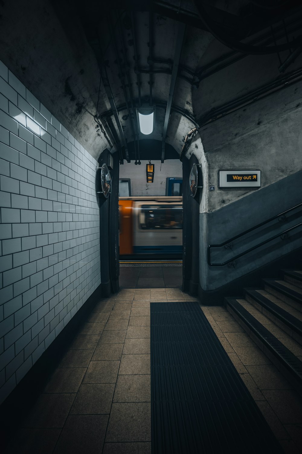 a subway station with a train passing by