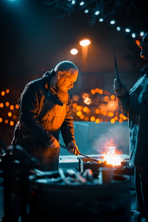 A blacksmith is working intensely at a forge, with a glowing fire illuminating his face and surroundings. The backdrop of warm, glowing lights adds a cozy atmosphere.