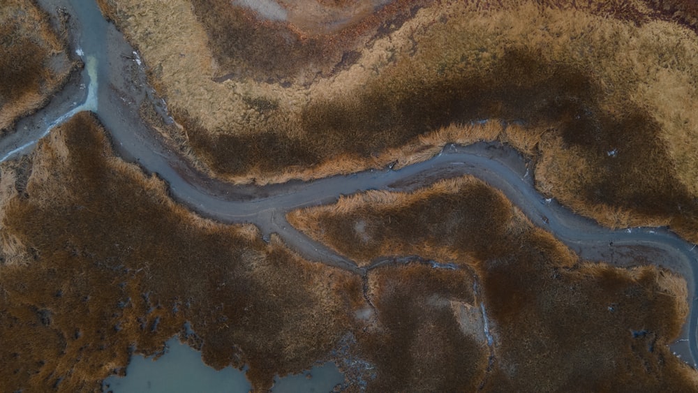 an aerial view of a river running through a field