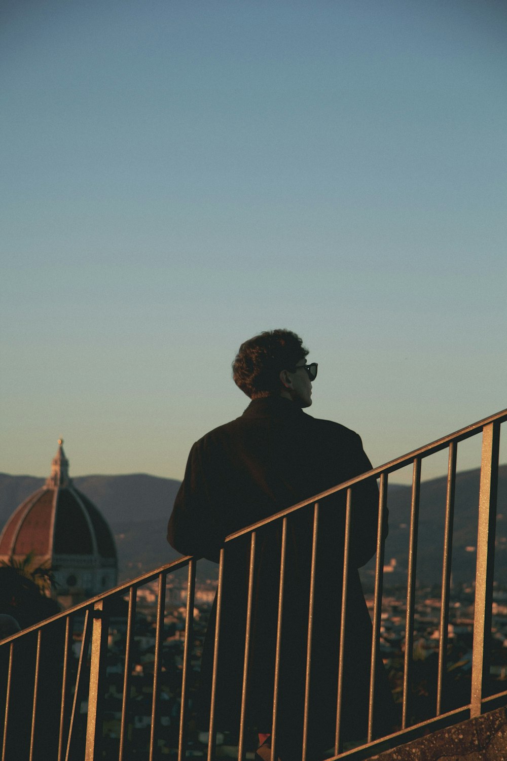 a man standing on top of a balcony next to a railing