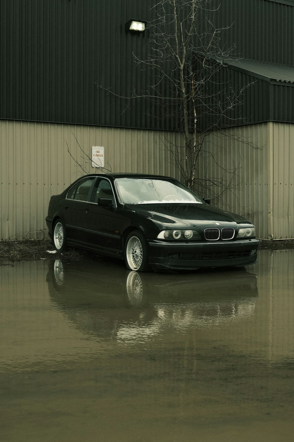 a black car parked in a flooded parking lot