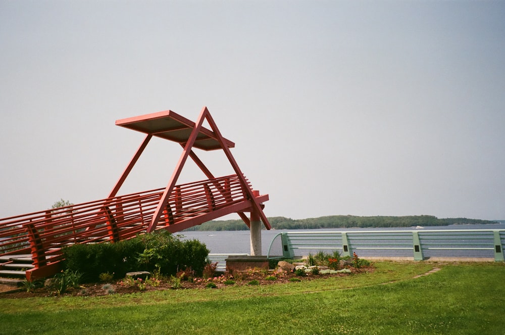 a red bench sitting on top of a lush green field