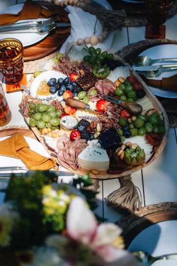 Elegant grazing board with a colorful mix of cheeses, nuts, and dried fruits arranged on a marble surface.