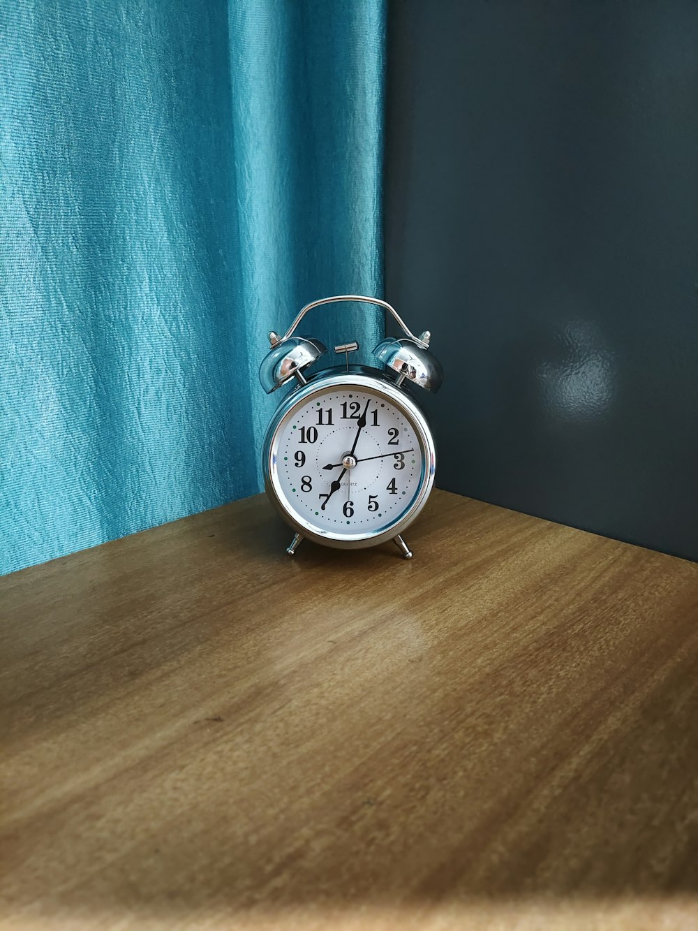 an alarm clock sitting on top of a wooden table
