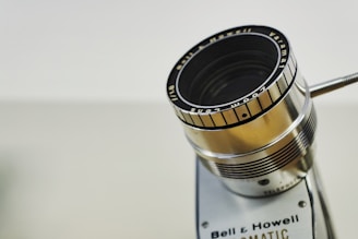 A close-up of a classic movie camera lens reflecting scenes from past heroic moments.