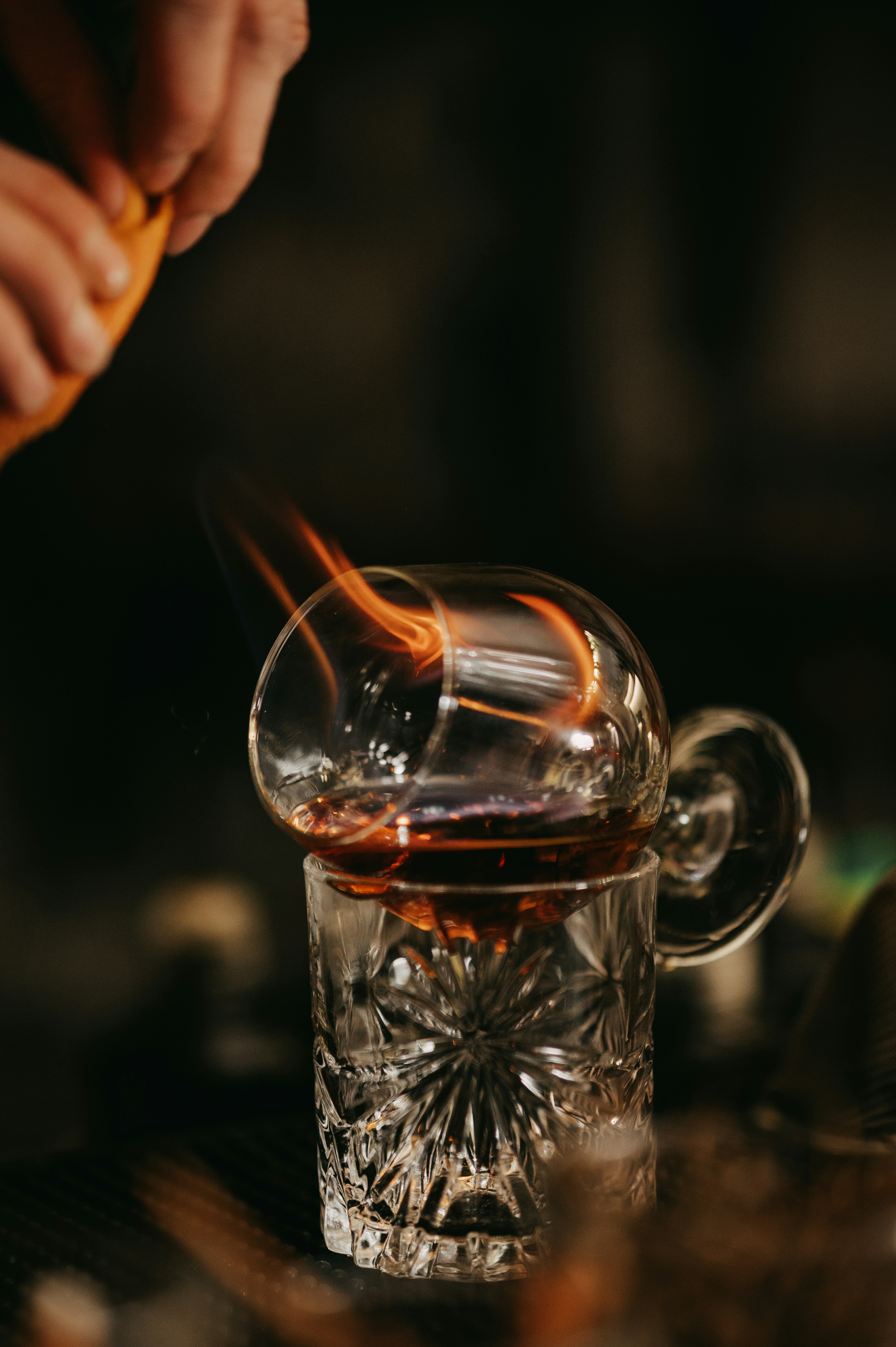 a person stirring a drink in a glass cup