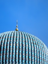 a blue dome with a gold top on a clear day