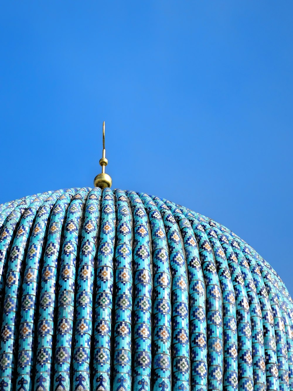 a blue dome with a gold top on a clear day