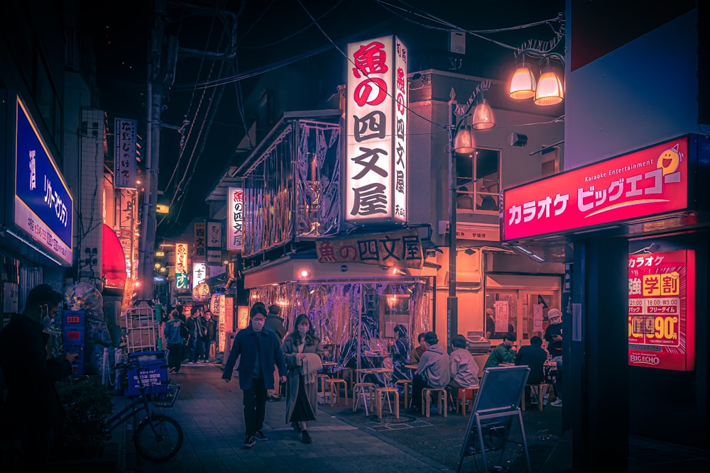 a group of people walking down a street at night