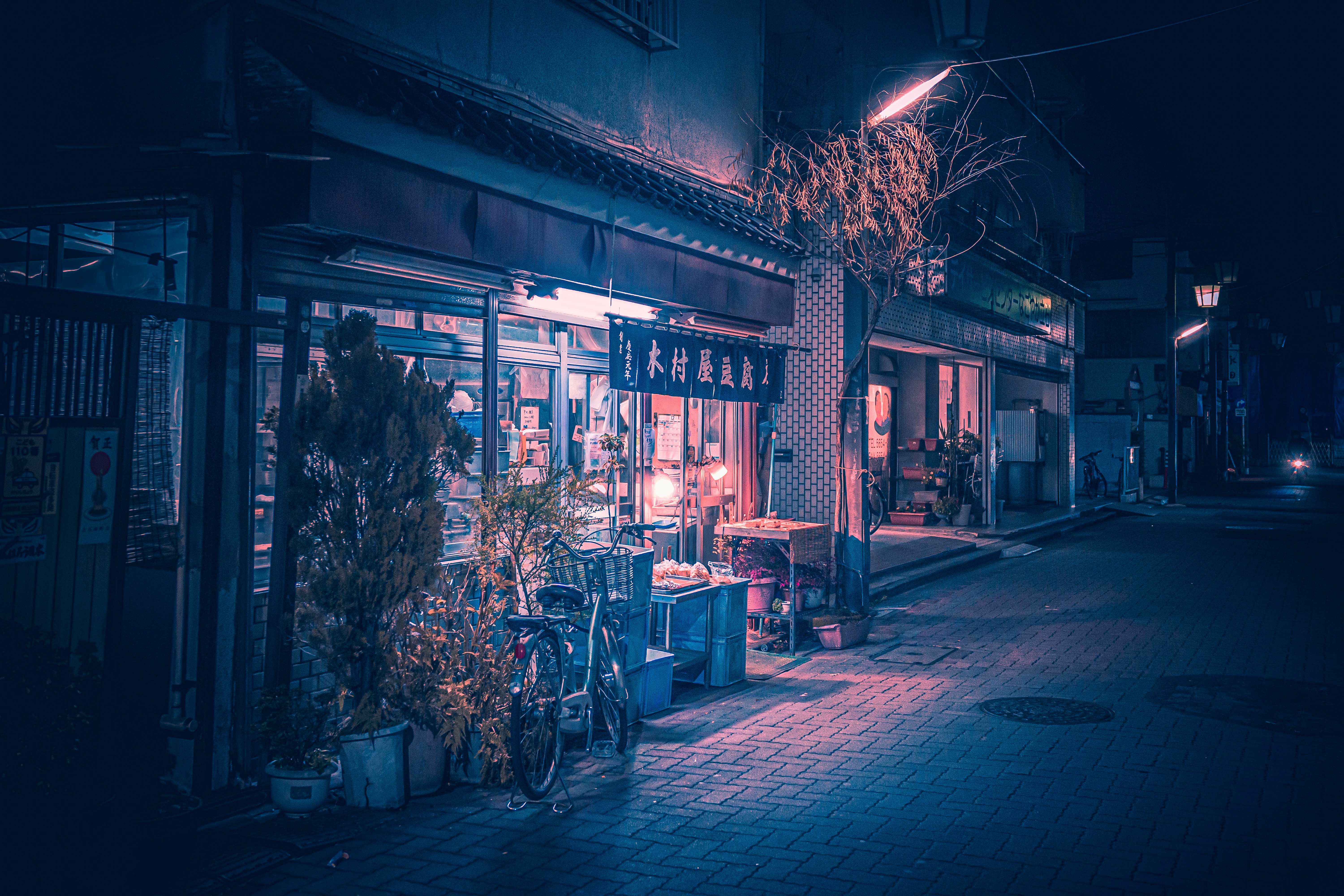 a dark street at night with a store front lit up
