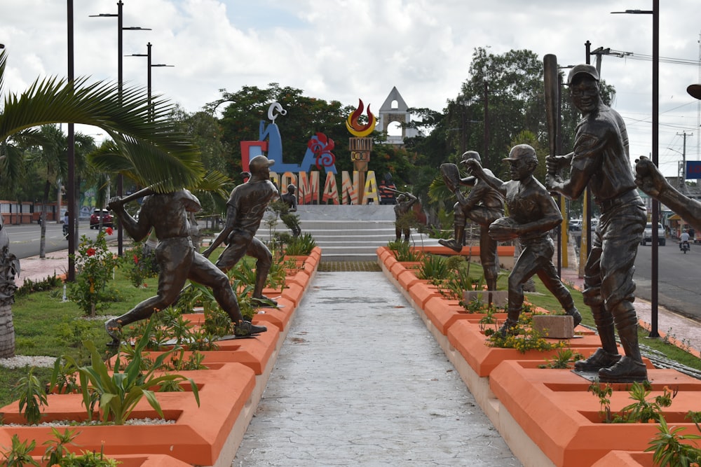 a group of statues of people playing baseball