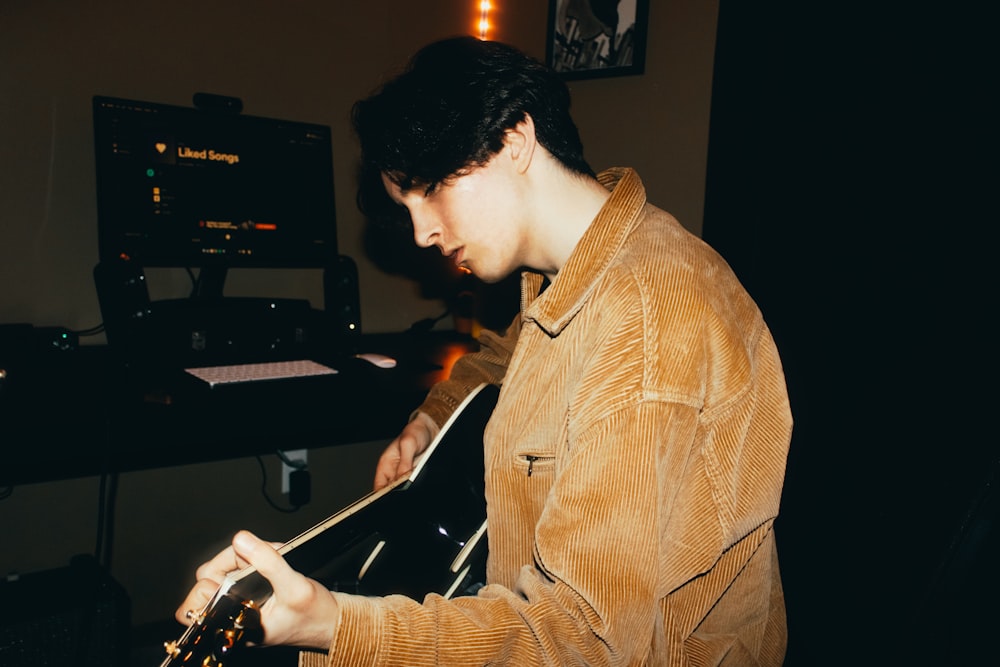 a man playing a guitar in a recording studio