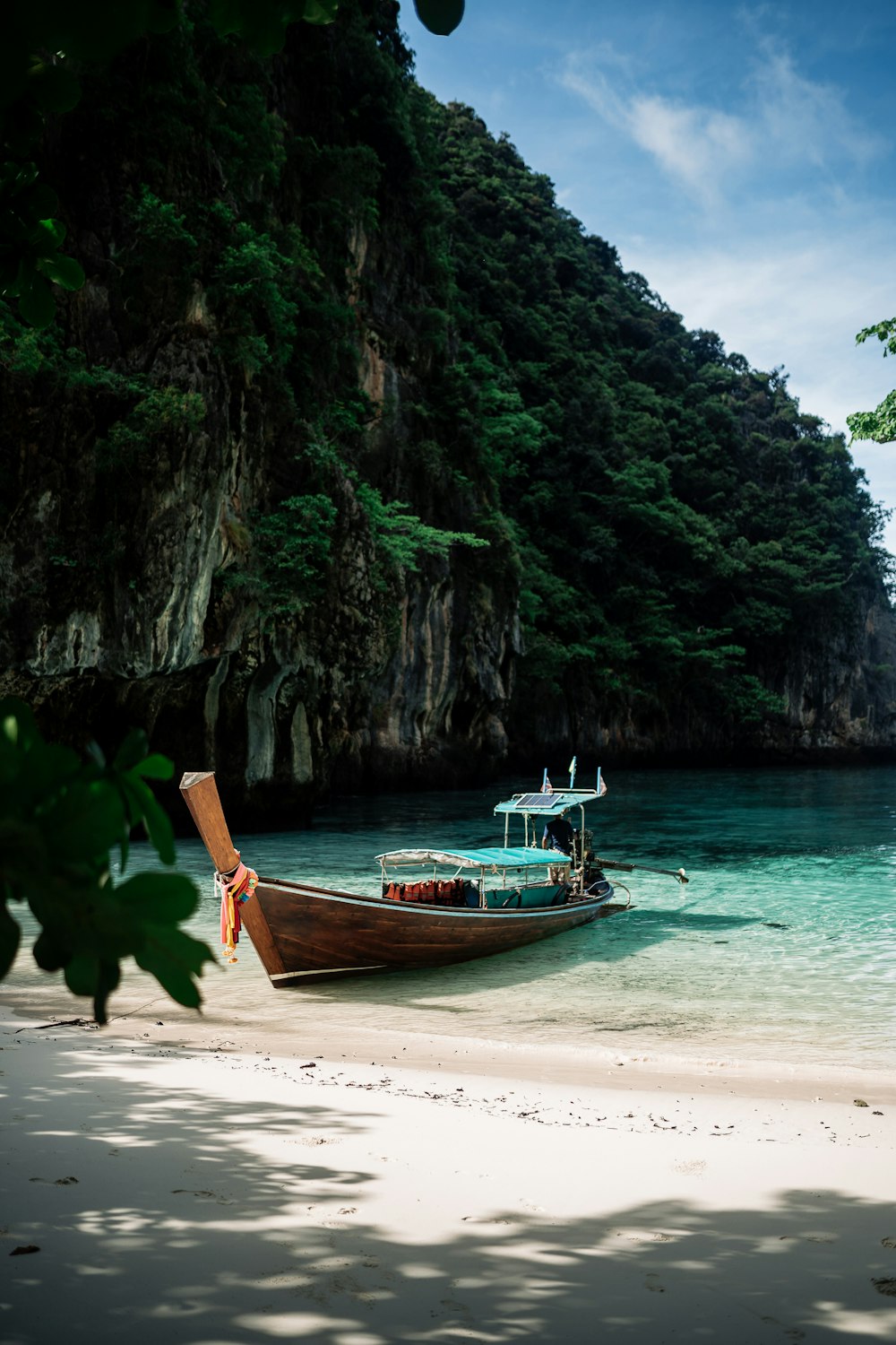 a boat on a beach near a mountain