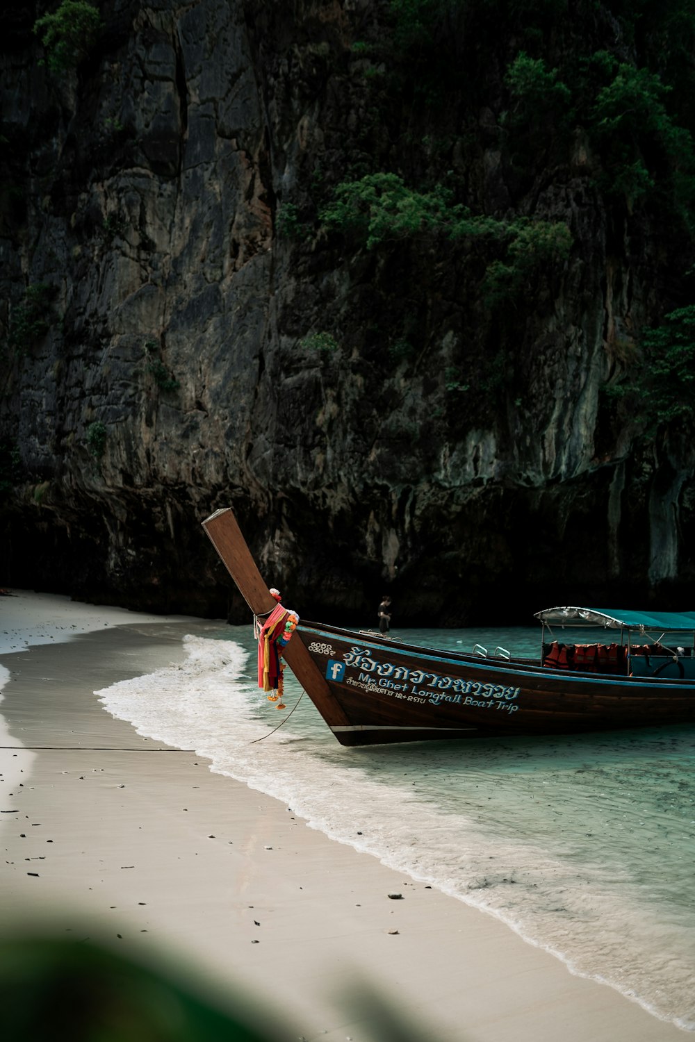 a long boat sitting on top of a sandy beach