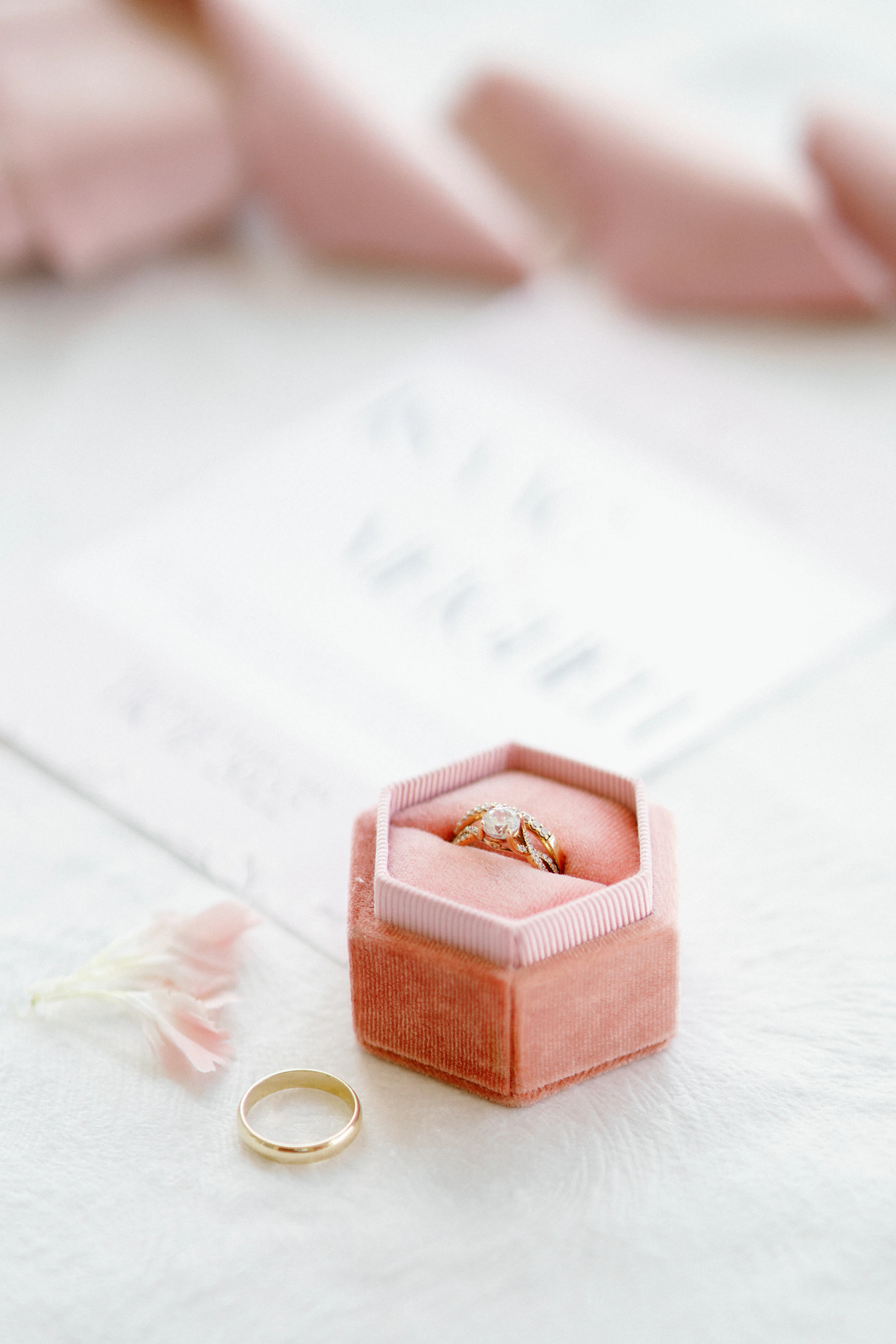 a pink ring box with two wedding rings in it