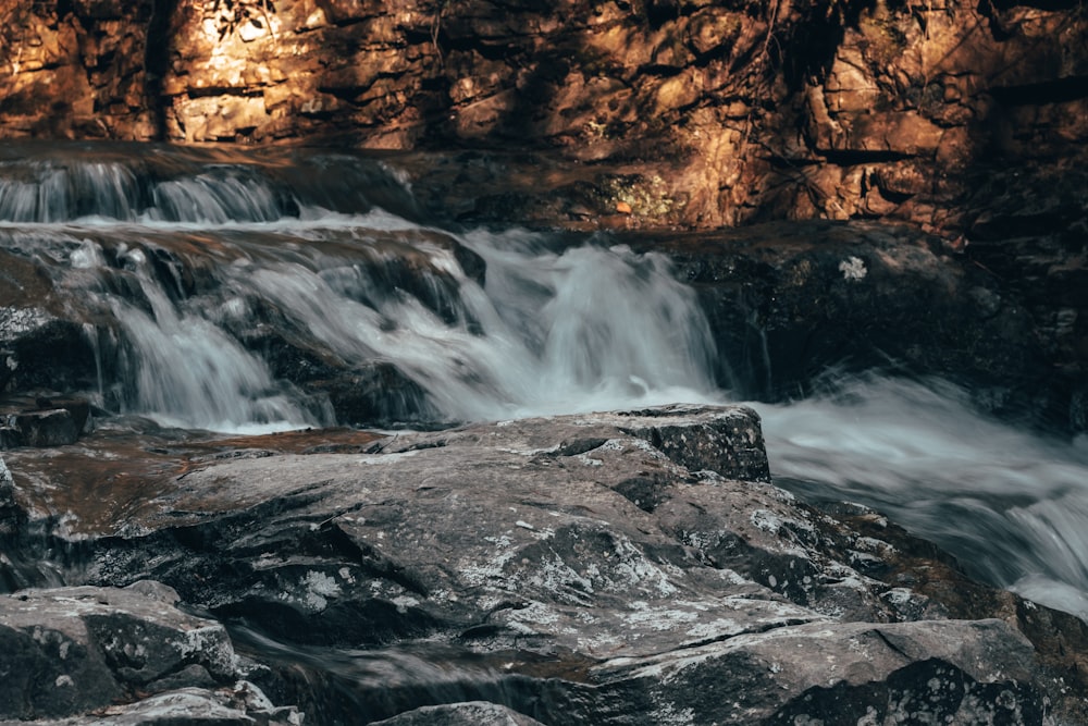 a close up of a waterfall with rocks and water