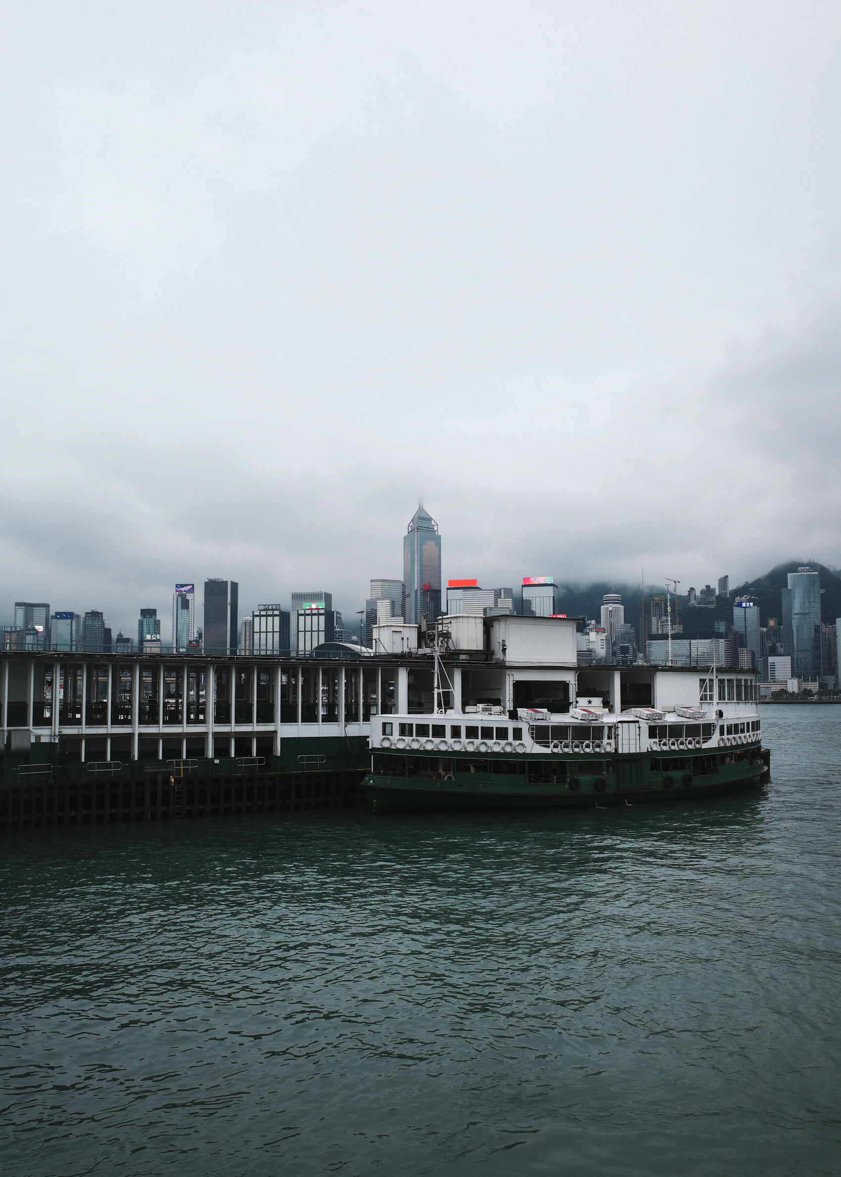A green-and-white Star Ferry crossing Victoria Harbour beneath Hong Kong's towers