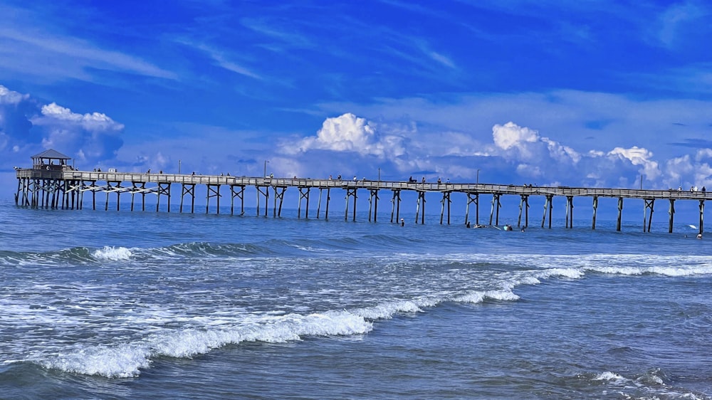 a long pier stretches out into the ocean