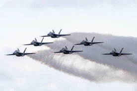 a formation of fighter jets flying through a cloudy sky