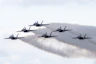 a formation of fighter jets flying through a cloudy sky