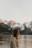 a woman standing in front of a lake with mountains in the background