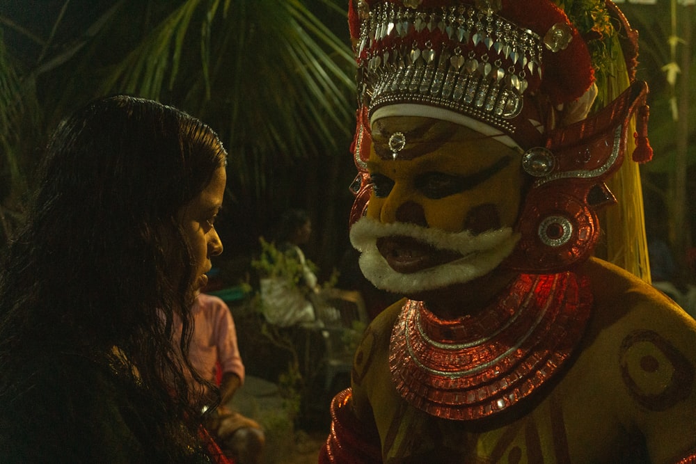 a woman standing next to a man in a costume