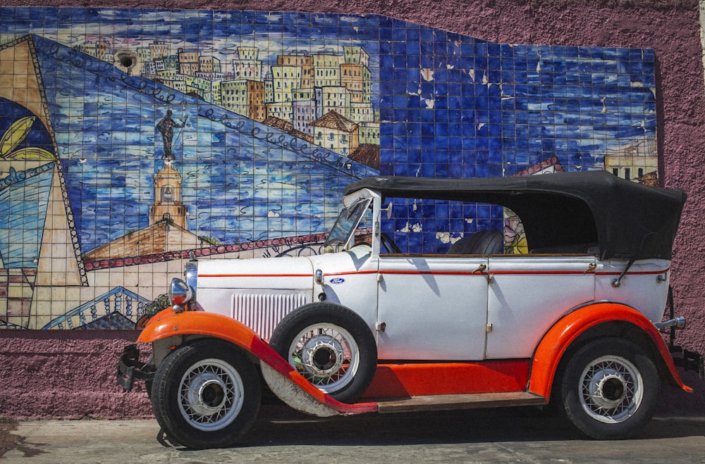 an orange and white car parked in front of a building