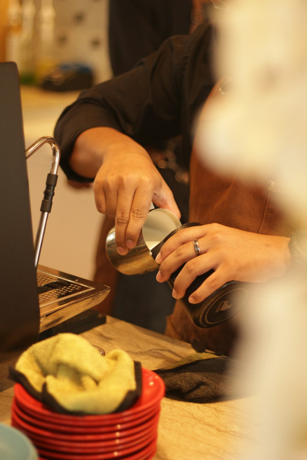 a person pouring something into a cup on a table