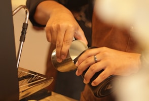 a person pouring something into a cup on a table