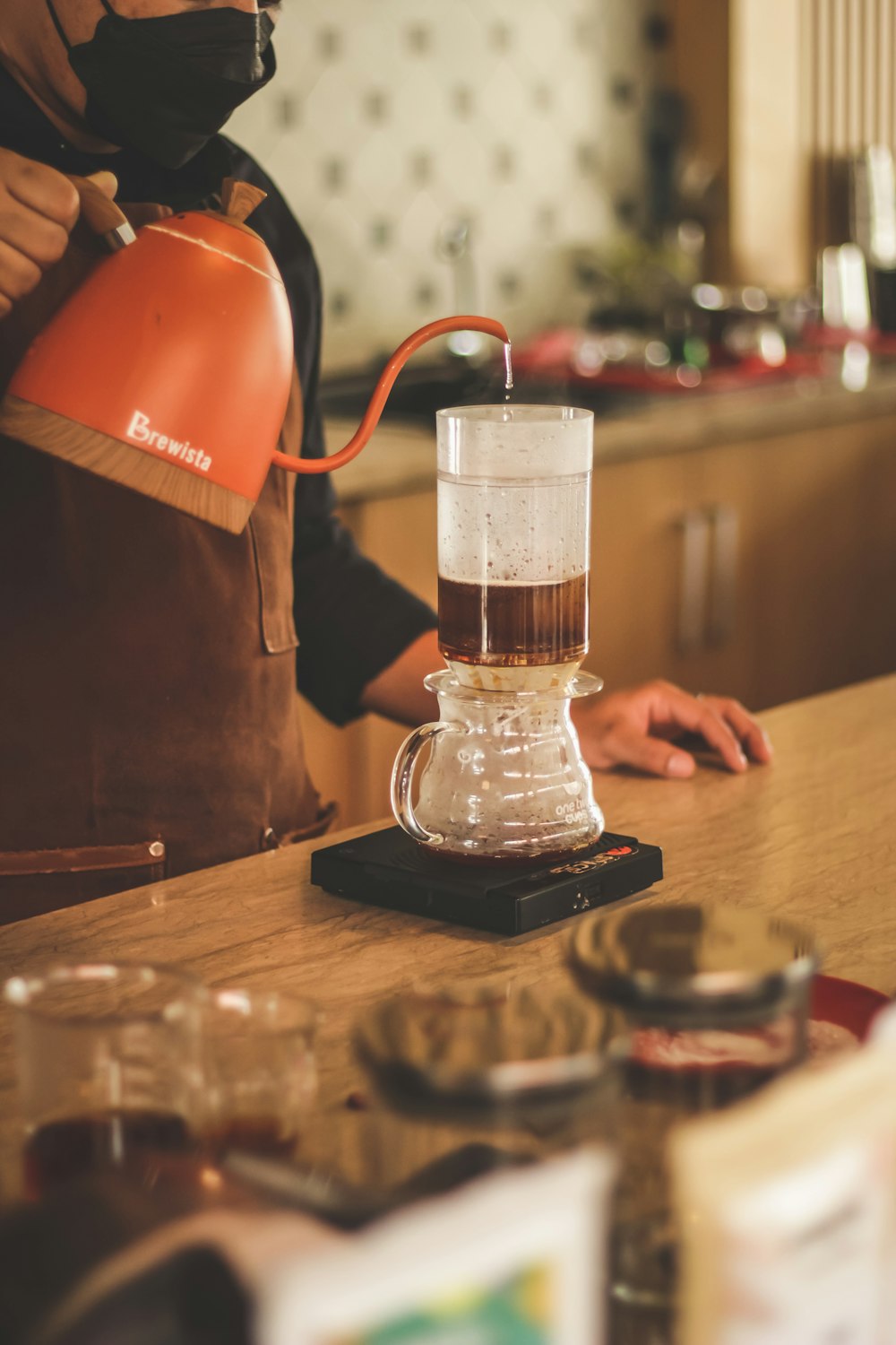 a person wearing a gas mask pours a cup of coffee