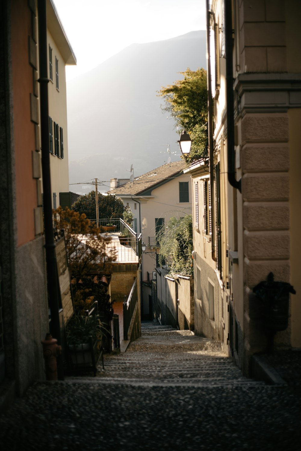 a narrow alley way with a lamp on the side