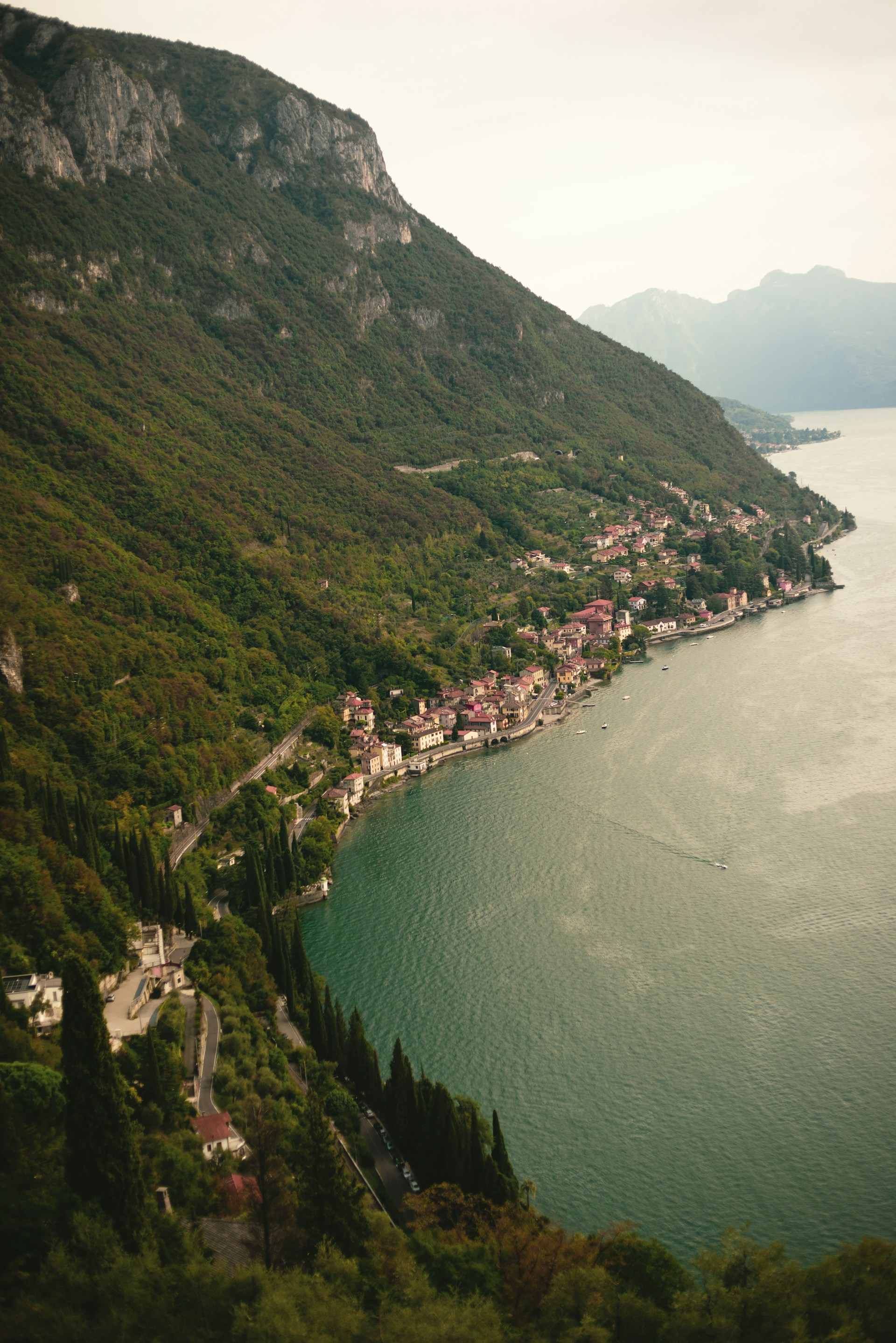 a scenic view of a small town on the shore of a lake
