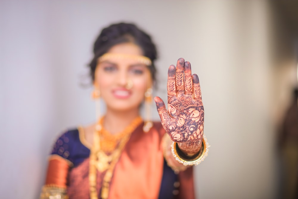 a woman holding up her hand with a henna on it