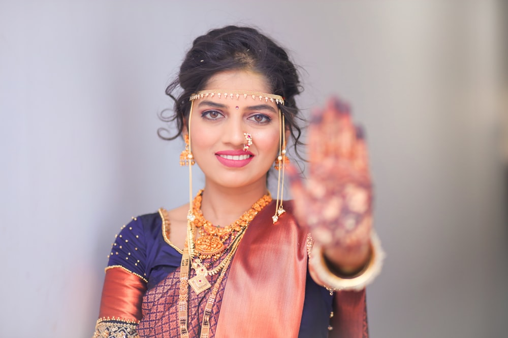 a woman in a sari holding her hand up