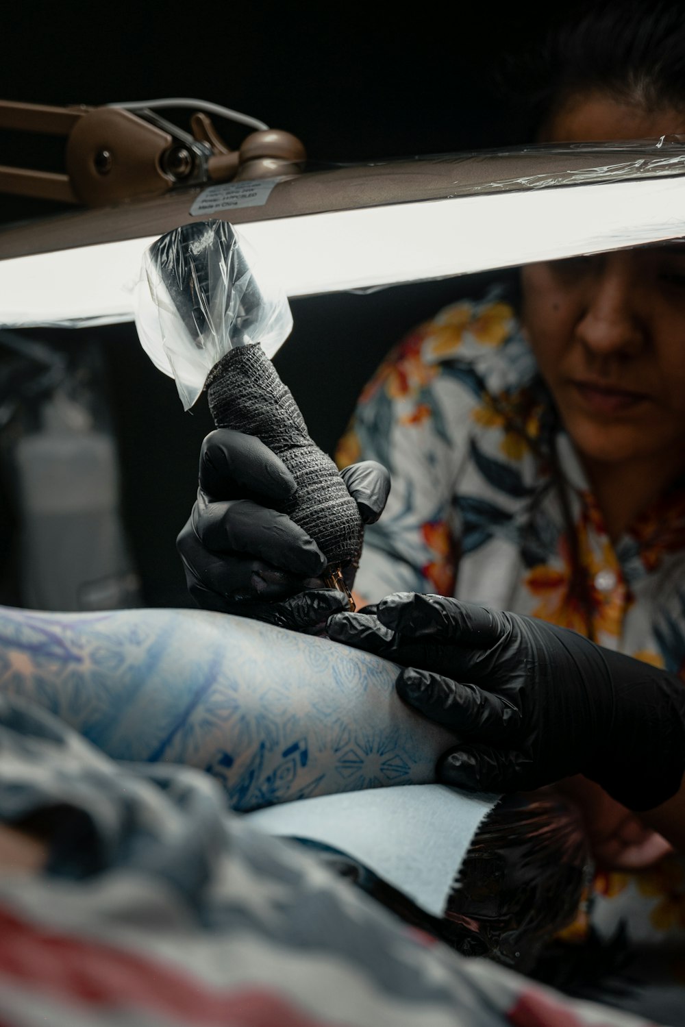 a woman getting her tattoo done by a tattoo artist