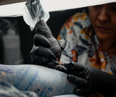 a woman getting her tattoo done by a tattoo artist