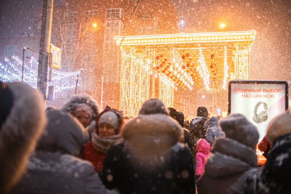 a crowd of people standing around a stage covered in snow