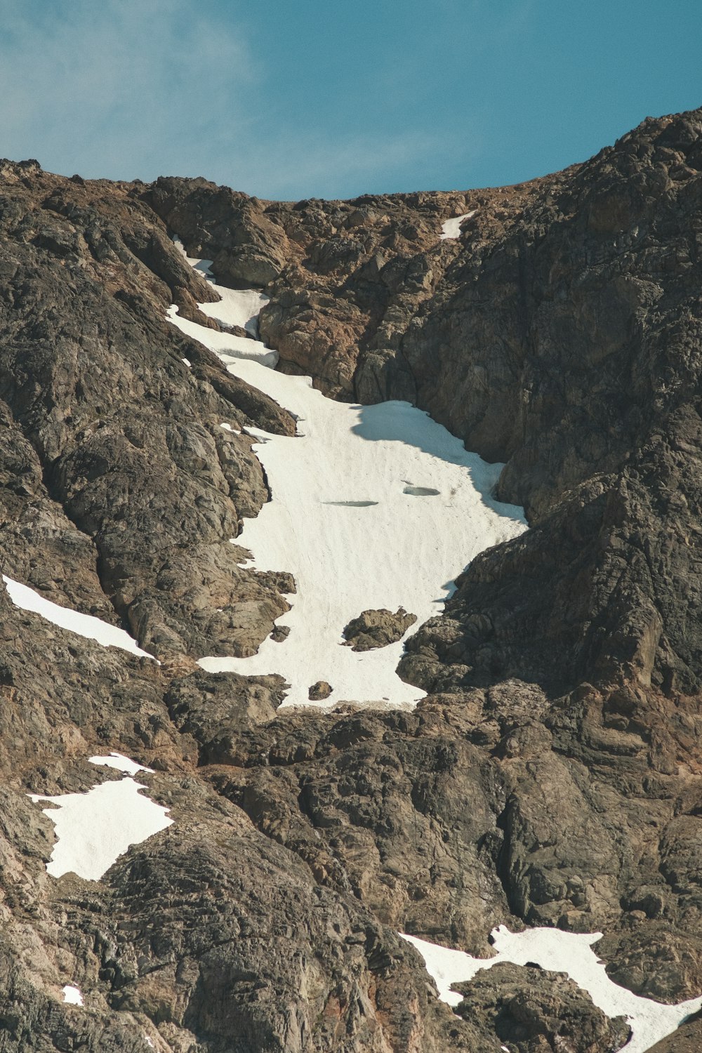 a snow covered mountain with rocks and snow