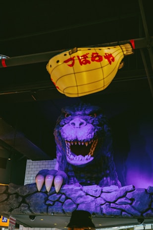 A fierce Godzilla toy towering over a miniature cityscape.