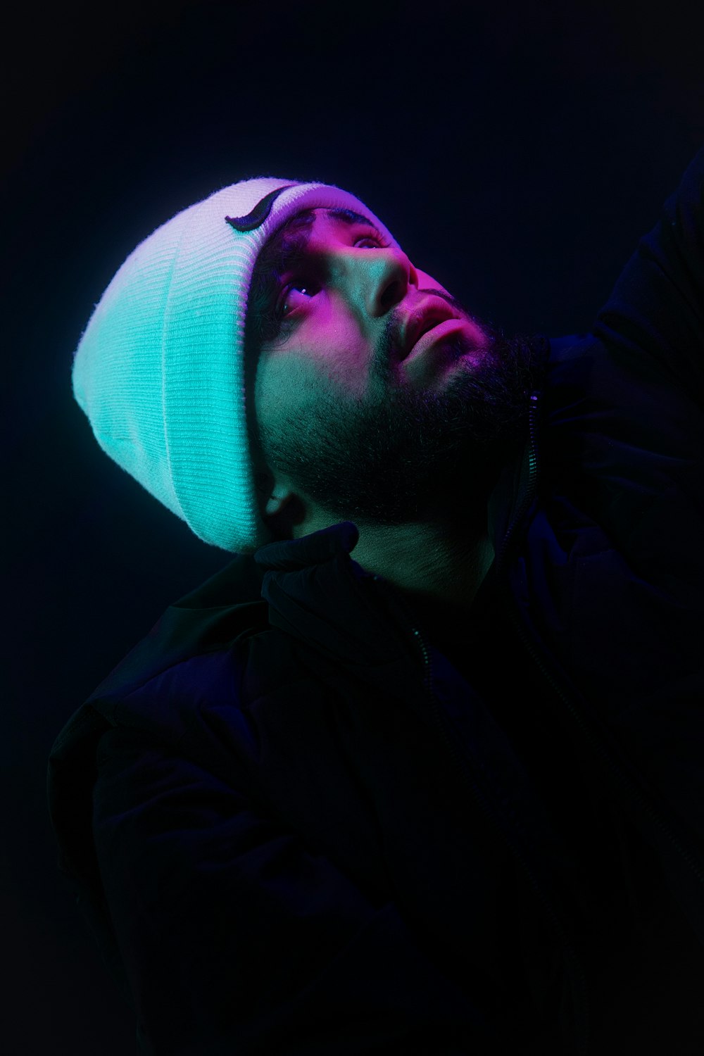Ein Mann mit einer Mütze auf dem Kopf im Dunkeln