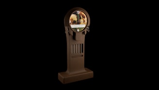 A vintage-style clock with a wooden texture is displayed against a dark background. The clock face features an artistic image with a blend of natural elements. It showcases a digital date and time display at the center, enclosed in an ornate wooden frame.