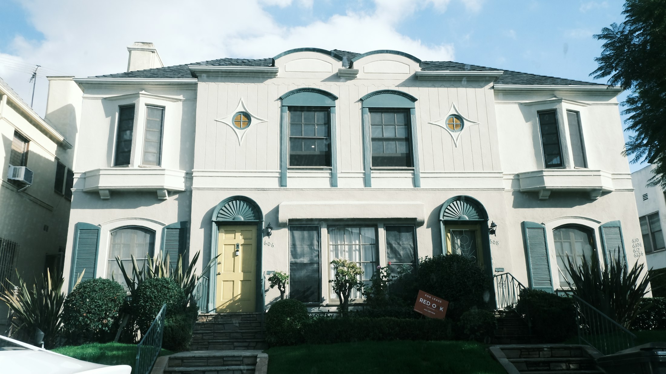 Two story white home with arched windows