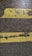 Two parallel yellow lines, worn and cracked, are painted on a rough, dark asphalt surface. The texture of the pavement and paint is visible, showing signs of wear and tear.