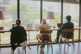 a couple of people sitting at a table in front of a window