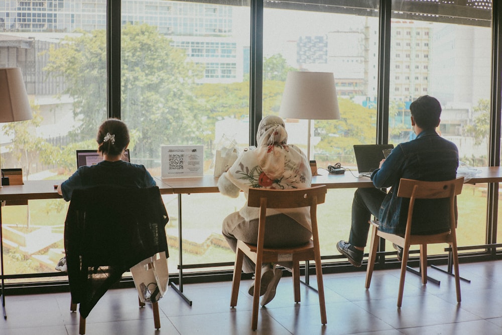 Un par de personas sentadas en una mesa frente a una ventana